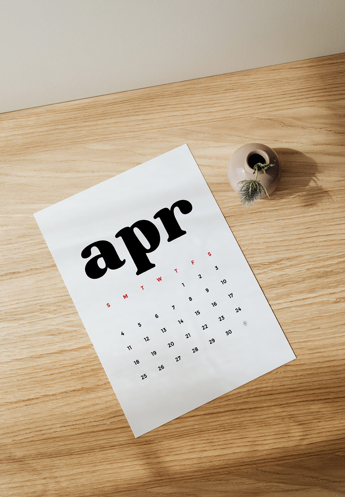 Little Gold Pixel • Free Printable 2021 Calendar • Download and print today! • Picture of the April 2021 printout on a wooden desktop, covered in shadows.